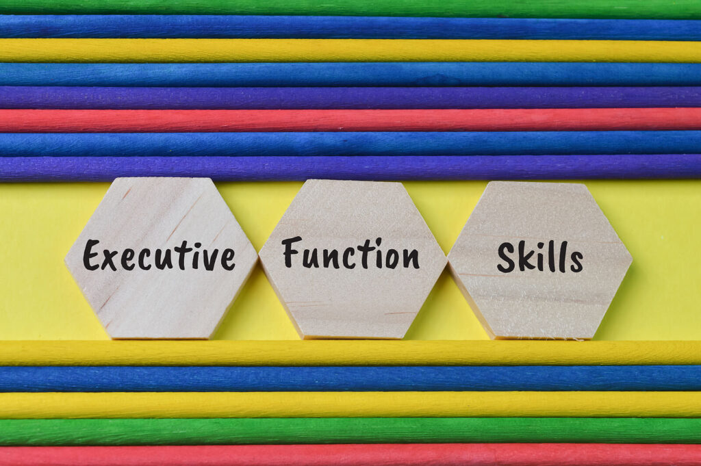 "Executive functioning skills" on wooden hexagon cut outs. Representing how executive functioning skills can impact your every day life. Reach out to an ADHD therapist in Charlotte, NC to get the support you deserve.